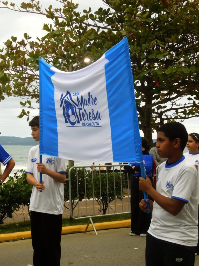 Crianças da Casa Madre Teresa de Calcutá com a bandeira da instituição